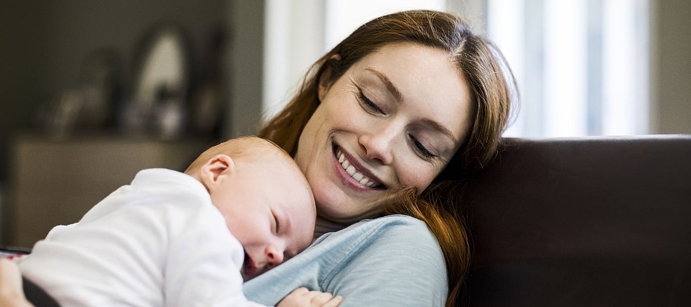 Mother cuddling newborn baby, sharing a moment.