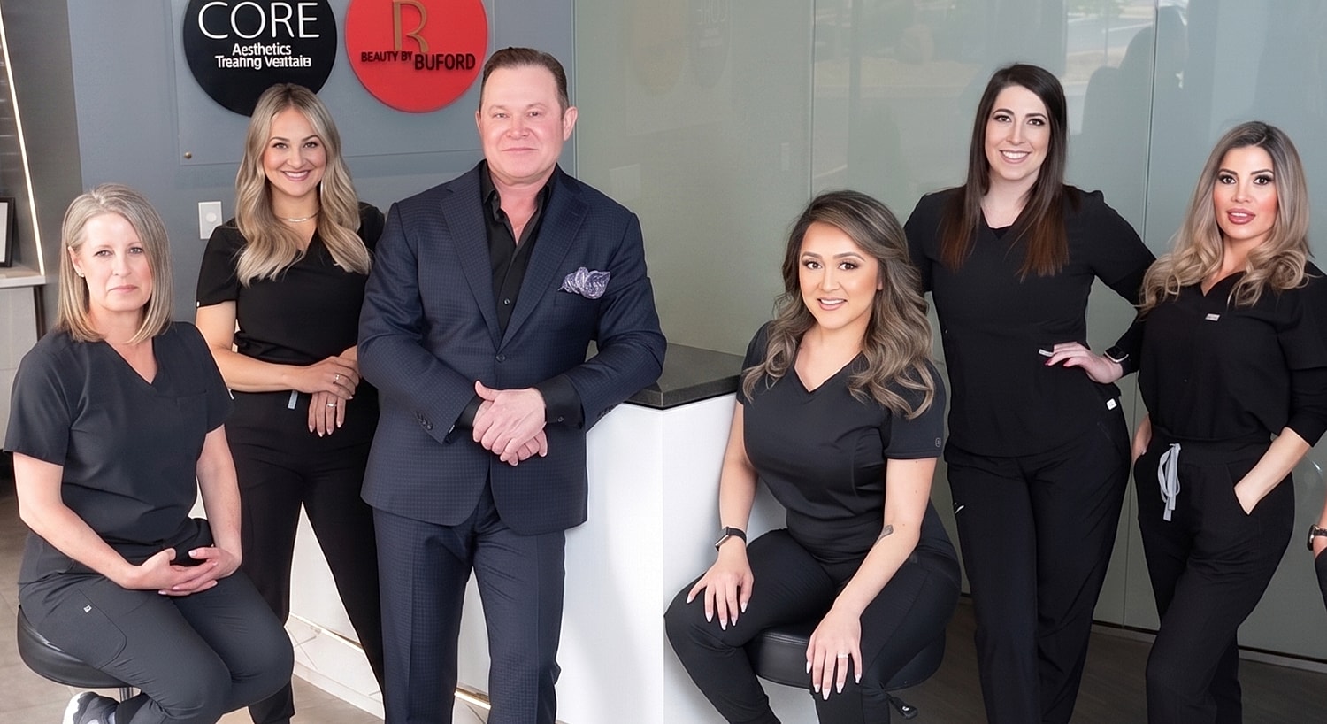 Aesthetic team posing in clinic setting.
