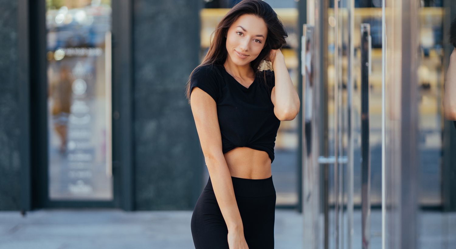 Young woman posing in stylish black outfit.