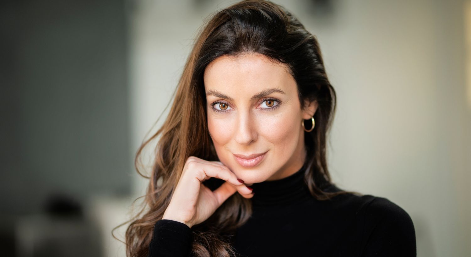 Woman with long hair in black turtleneck sweater.