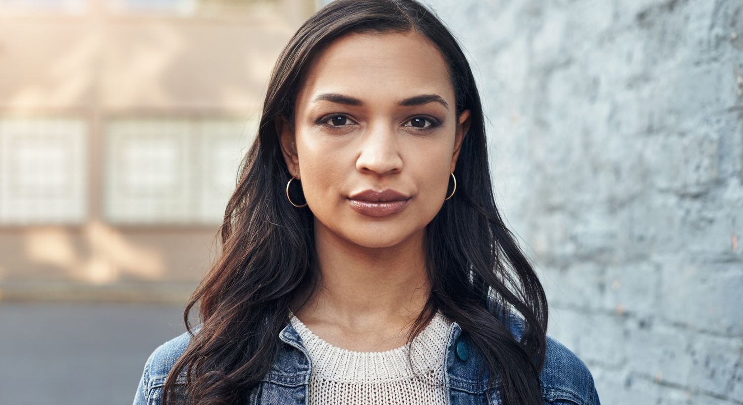 Young woman with long hair and denim jacket.