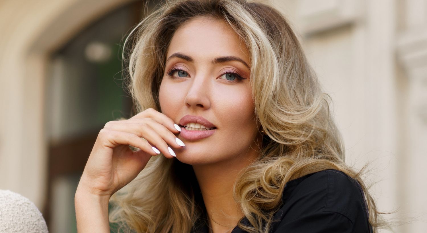 Woman with blonde hair smiling and posing.