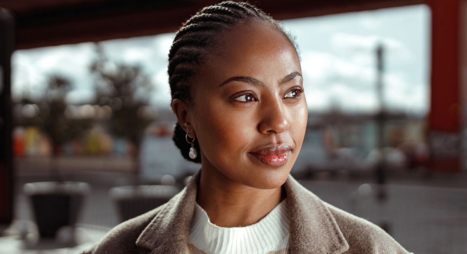 Woman with braided hair, outdoors in daylight.