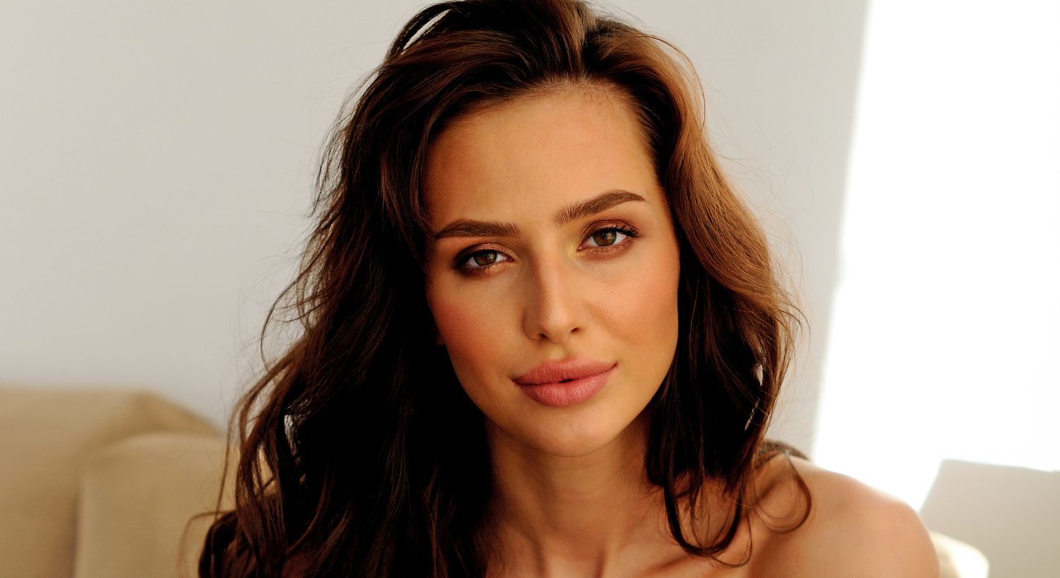 Woman with long brown hair and natural makeup.