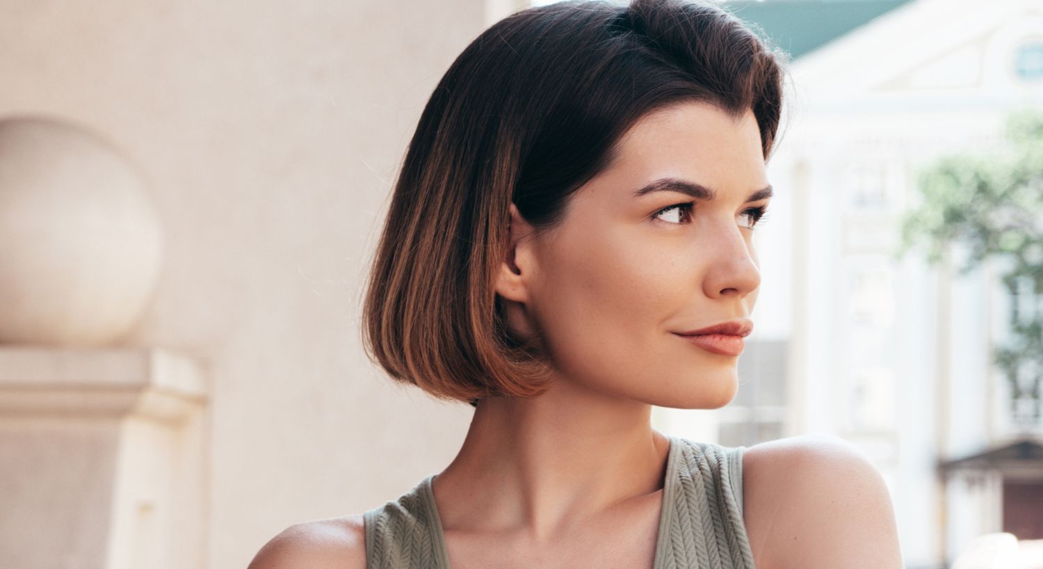 Woman with bob hairstyle looking thoughtfully outdoors