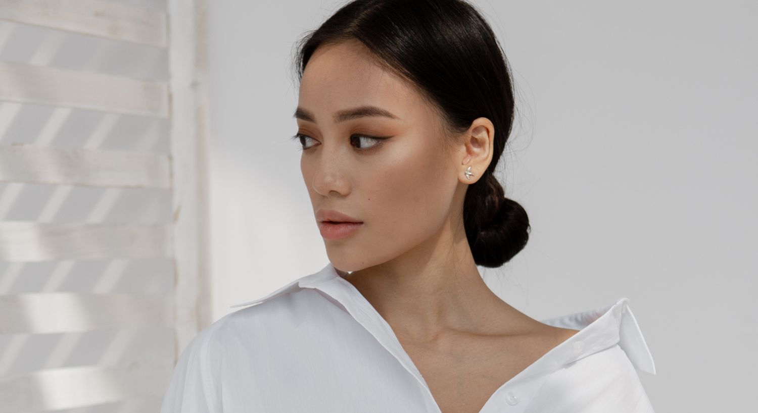 Woman in white shirt with elegant hairstyle.